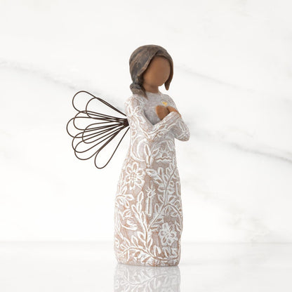 Side_view_of_Willow_Tree_Remembrance_Angel_darker_skin_figurine_holding_a_gold_heart