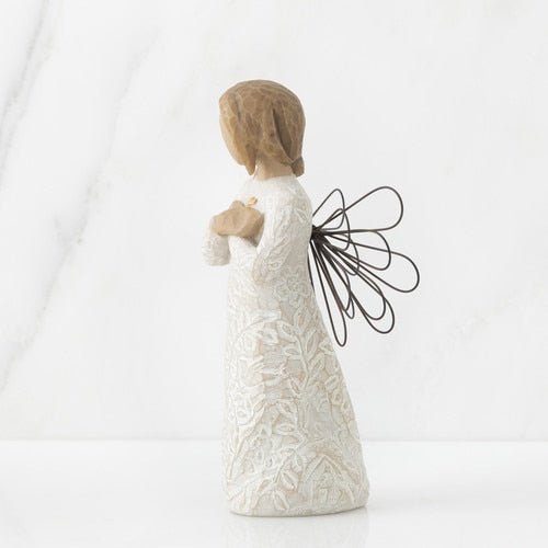 Side view of Willow Tree Remembrance Angel figurine holding a gold heart